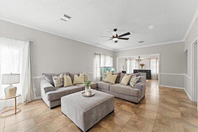 tiled living room featuring crown molding, ceiling fan with notable chandelier, and a textured ceiling