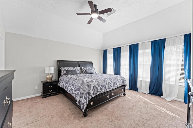 bedroom with ceiling fan, lofted ceiling, carpet flooring, and a textured ceiling