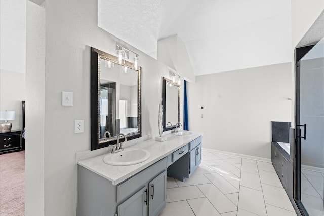 bathroom with vanity, lofted ceiling, tiled bath, and tile patterned floors