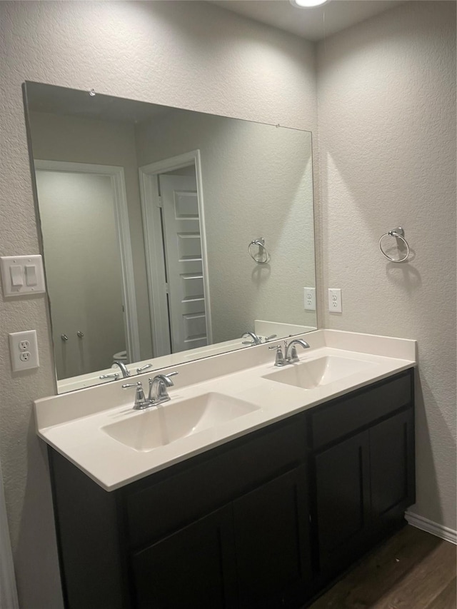 bathroom featuring toilet, vanity, and hardwood / wood-style floors