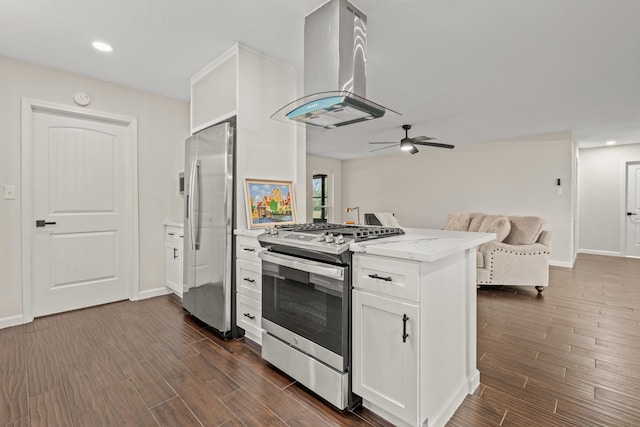 kitchen featuring kitchen peninsula, appliances with stainless steel finishes, island range hood, and white cabinets