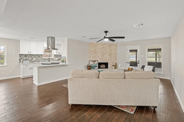 living room with ceiling fan, dark hardwood / wood-style floors, and a fireplace