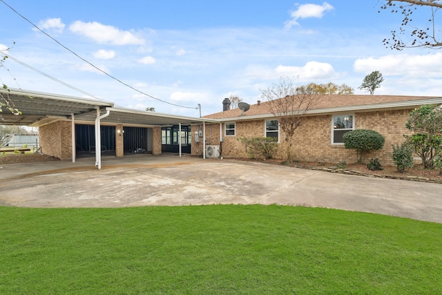 rear view of house with a carport and a lawn