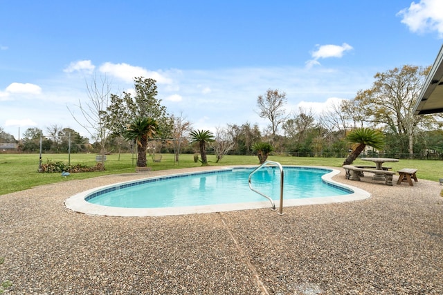 view of swimming pool with a patio area and a yard