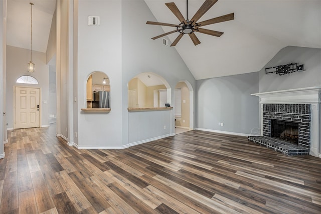 unfurnished living room featuring high vaulted ceiling, a fireplace, ceiling fan, and dark hardwood / wood-style floors