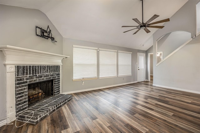 unfurnished living room with lofted ceiling, a brick fireplace, ceiling fan, and dark hardwood / wood-style floors