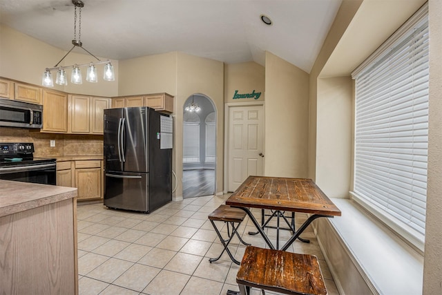 kitchen with pendant lighting, light tile patterned floors, decorative backsplash, appliances with stainless steel finishes, and light brown cabinets