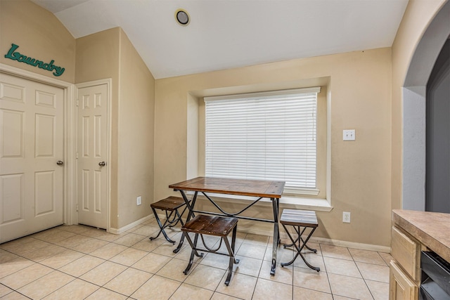 tiled dining room with vaulted ceiling