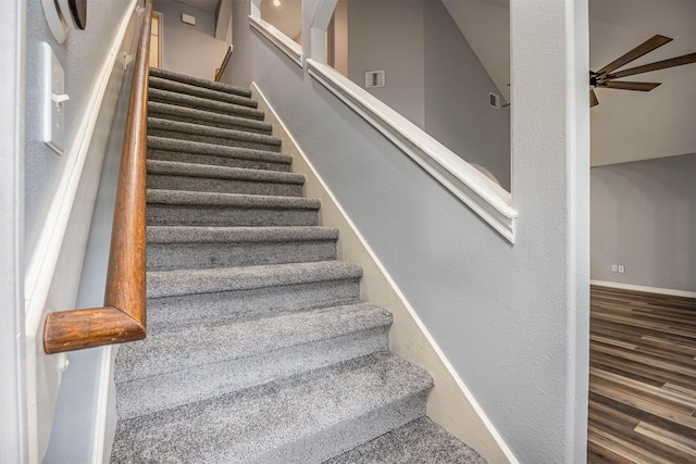 stairway featuring ceiling fan and wood-type flooring