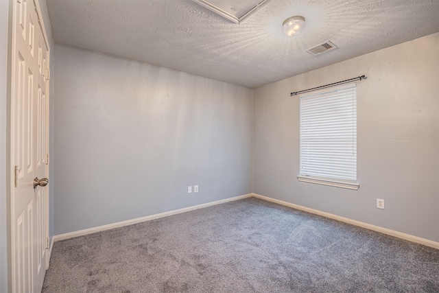 carpeted empty room featuring a textured ceiling