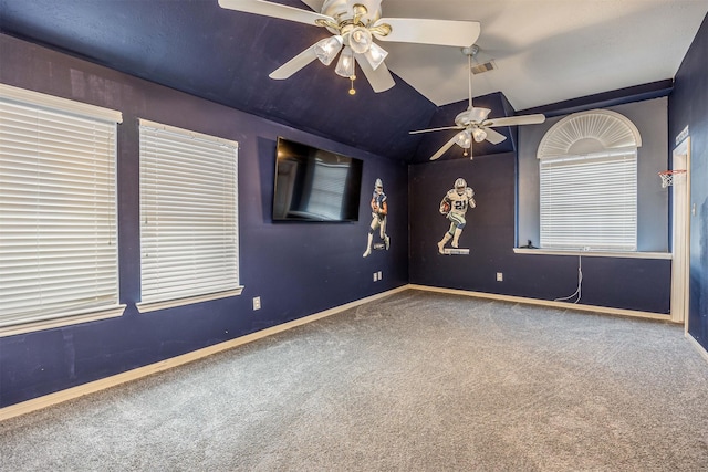 spare room featuring ceiling fan, vaulted ceiling, and carpet flooring