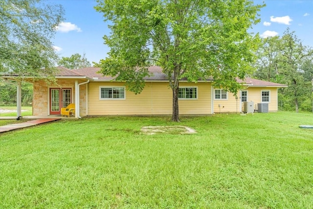 back of property with a yard and central air condition unit