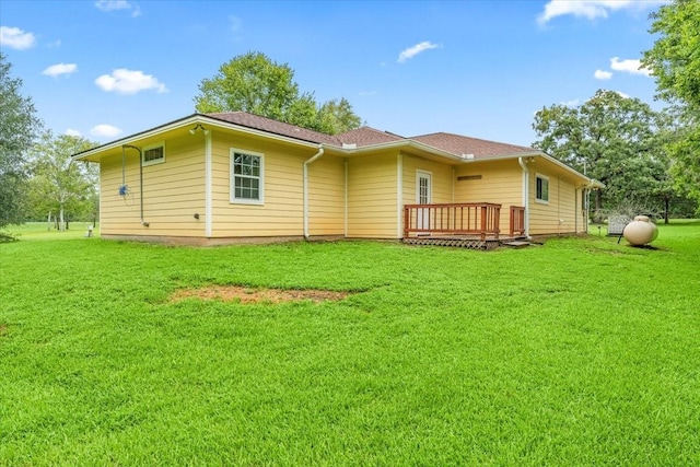 rear view of property featuring a deck and a lawn