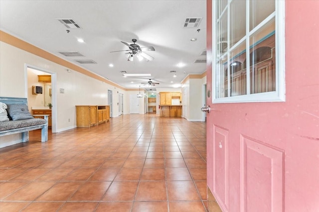 living room with tile patterned flooring, ceiling fan, and ornamental molding