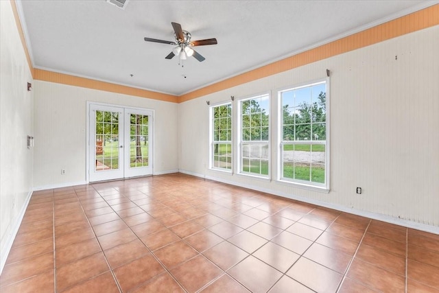 empty room with ceiling fan, french doors, light tile patterned floors, and ornamental molding