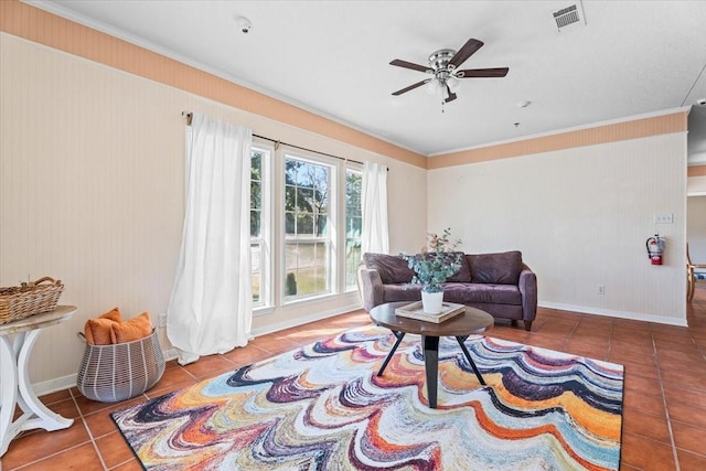 tiled living room with ceiling fan and crown molding