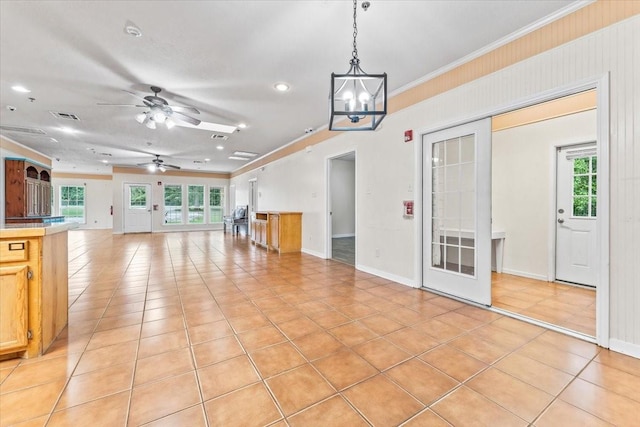 interior space with ceiling fan with notable chandelier, light tile patterned floors, ornamental molding, and french doors