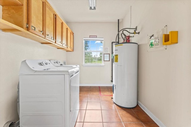 laundry room featuring washing machine and dryer, electric water heater, light tile patterned floors, and cabinets