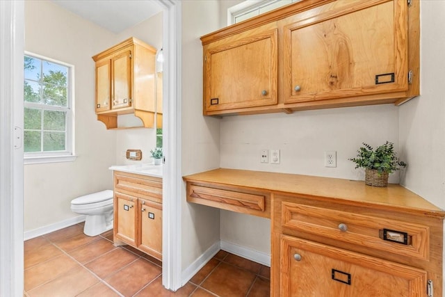 interior space featuring light tile patterned floors and built in desk