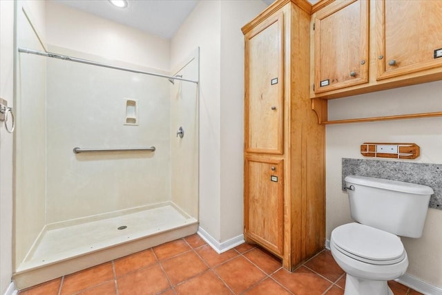 bathroom featuring tile patterned flooring, toilet, and a shower