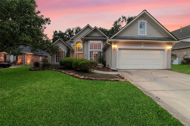 view of front of home with a yard and a garage