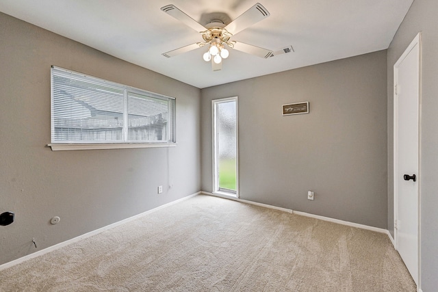 carpeted spare room with plenty of natural light and ceiling fan