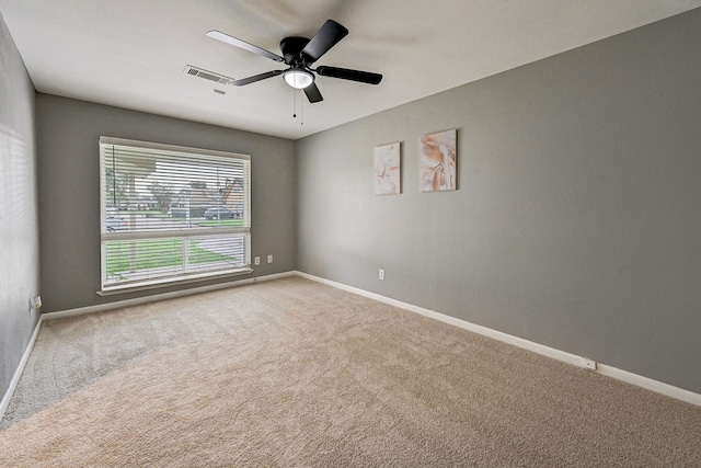 carpeted spare room featuring ceiling fan