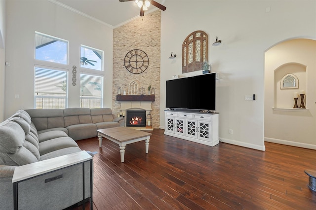 living room featuring a fireplace, high vaulted ceiling, dark wood-type flooring, and ornamental molding