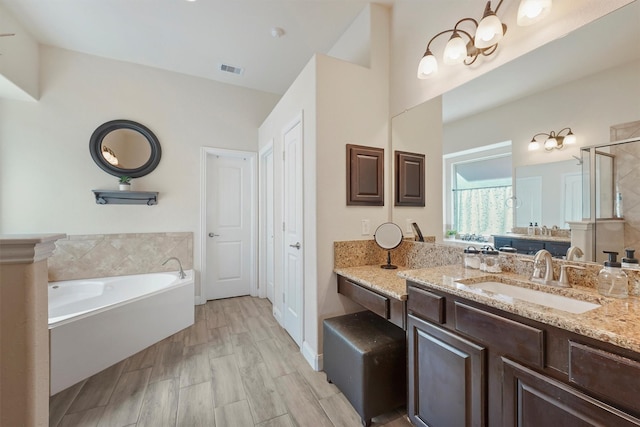 bathroom with hardwood / wood-style flooring, vanity, and plus walk in shower