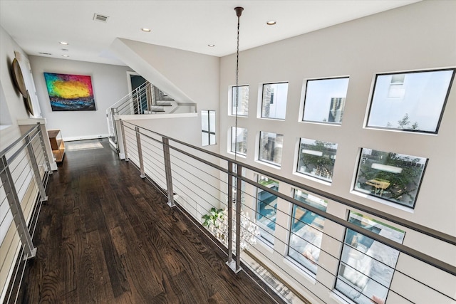 hall featuring a healthy amount of sunlight and dark hardwood / wood-style flooring