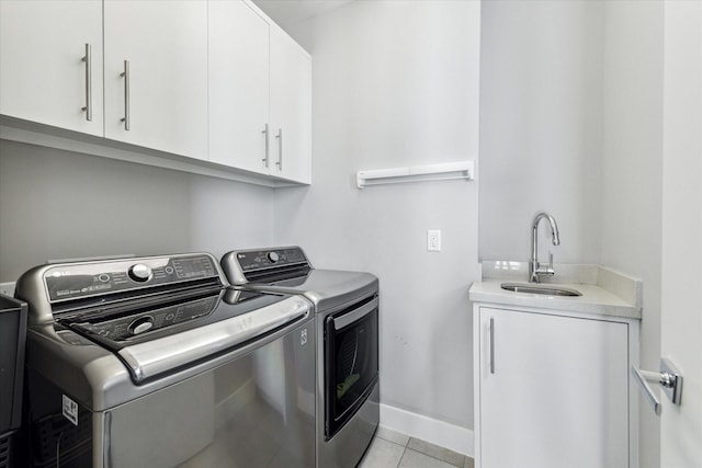 laundry area featuring sink, washer and clothes dryer, light tile patterned floors, and cabinets