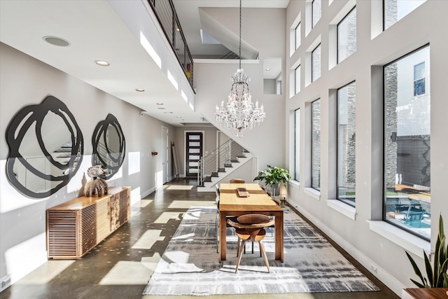 hallway featuring an inviting chandelier and a towering ceiling