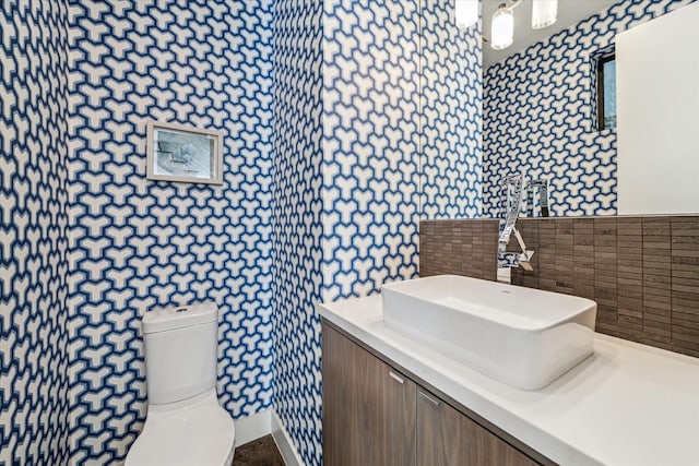 bathroom with tile walls, vanity, and toilet