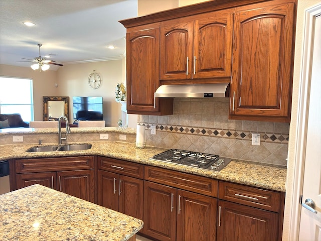 kitchen featuring stainless steel gas stovetop, backsplash, ventilation hood, sink, and ceiling fan