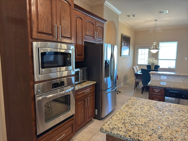 kitchen with appliances with stainless steel finishes, light stone counters, ornamental molding, decorative light fixtures, and light tile patterned flooring