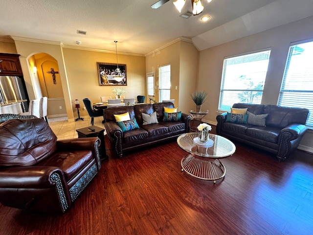 living room featuring hardwood / wood-style floors, ceiling fan, crown molding, and vaulted ceiling