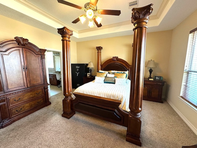 bedroom with light carpet, a tray ceiling, ceiling fan, and crown molding