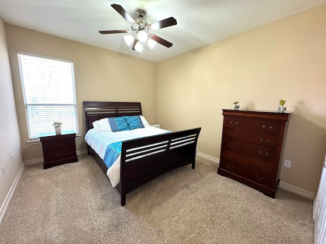 carpeted bedroom featuring a textured ceiling and ceiling fan