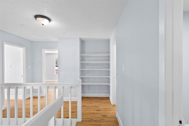 corridor featuring a textured ceiling and hardwood / wood-style flooring