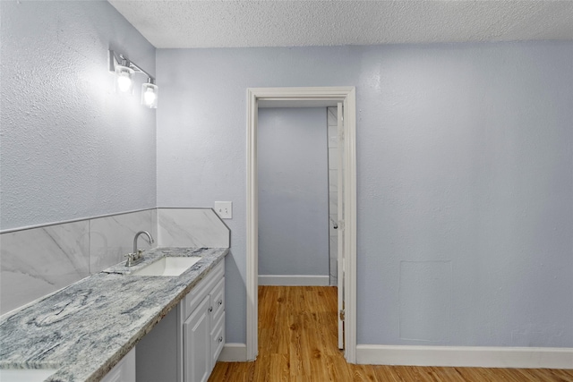 bathroom featuring hardwood / wood-style floors, vanity, and a textured ceiling