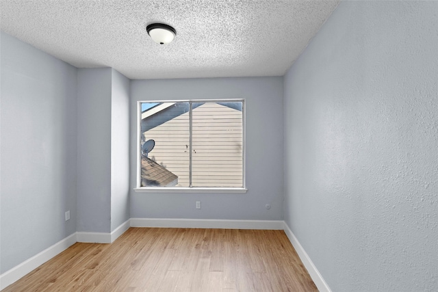 spare room with light hardwood / wood-style flooring and a textured ceiling