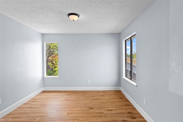 empty room featuring a textured ceiling and light wood-type flooring