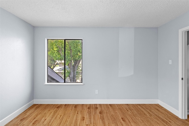 unfurnished room with light hardwood / wood-style floors and a textured ceiling