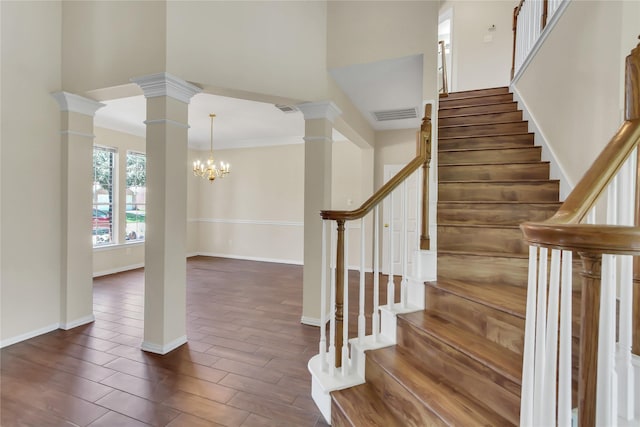 staircase with ornamental molding and an inviting chandelier