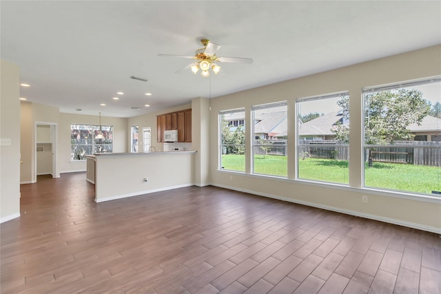 unfurnished living room featuring ceiling fan and hardwood / wood-style floors