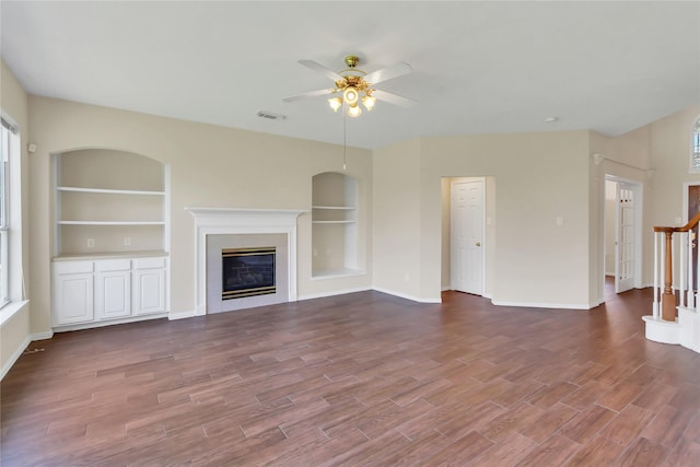 unfurnished living room with built in features and ceiling fan