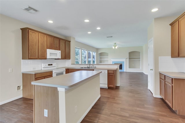 kitchen with ceiling fan, a center island, light wood-type flooring, and white appliances