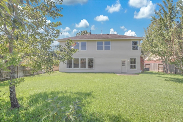 rear view of house featuring a lawn