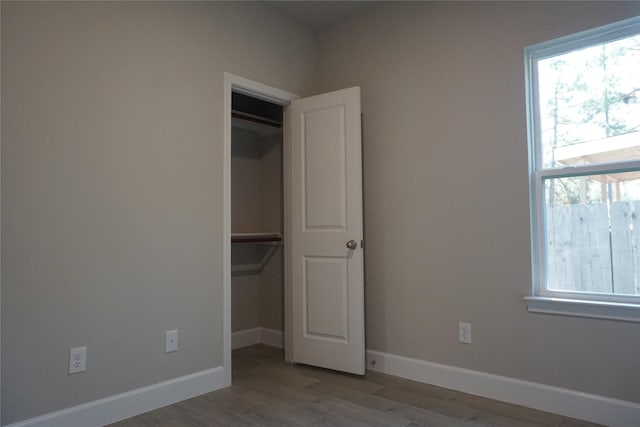 unfurnished bedroom with hardwood / wood-style floors and a closet