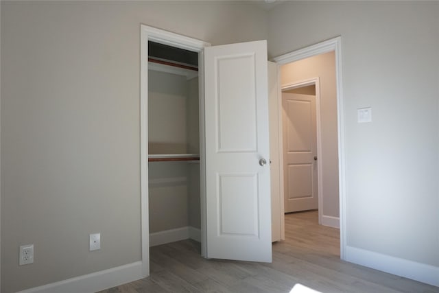 unfurnished bedroom featuring light wood-type flooring and a closet